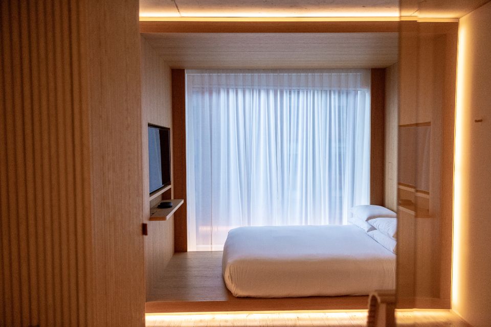 Warm, minimalist hotel bedroom with soft ambient lighting